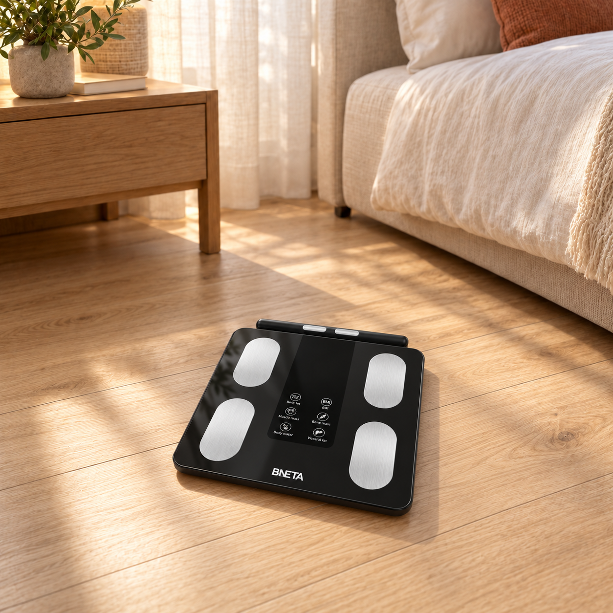 CS20H_Life1 - BNETA Black digital bathroom scale with four silver foot pads placed on a wooden bedroom floor near a bed, bathed in natural light.